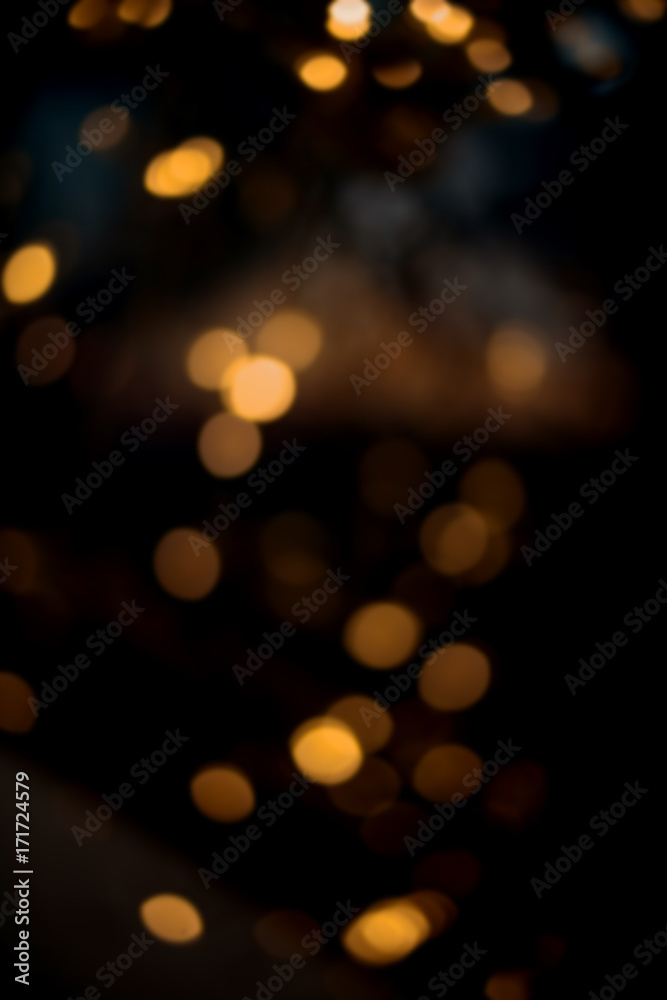 Fototapeta premium Boże Narodzenie tło z żółtym bokeh i migotały nieostre światła. Świąteczne rozmycie tła złocistego i czarnego światła.