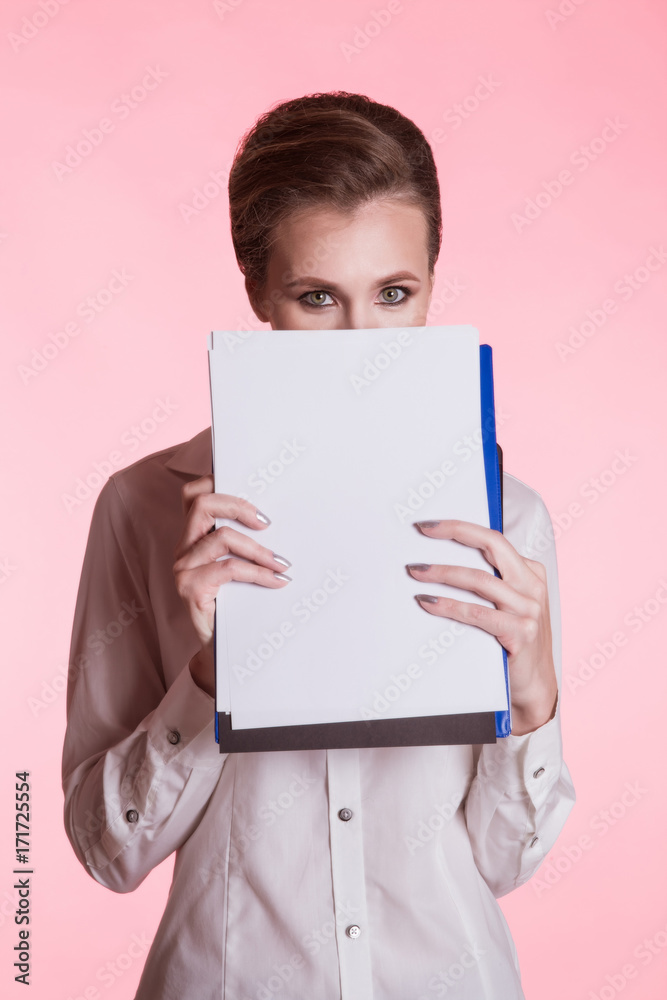 Business woman with a blank sheet covers her face, on a pink background Business woman with a blank sheet covers her face, on a pink background