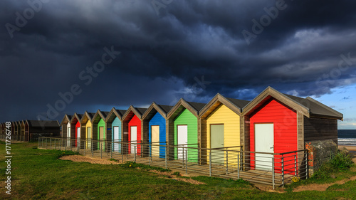 Threatening sky above Blyth beach huts, Northumberland, England