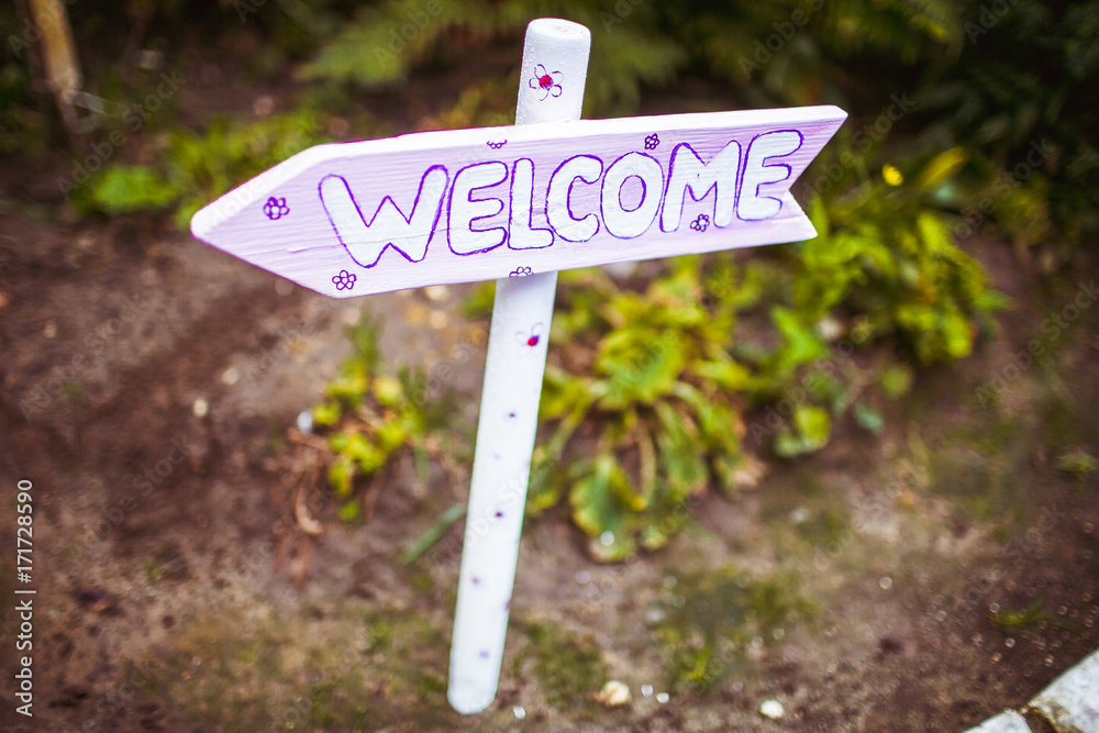 Arrow with word 'Welcome' stands on the road