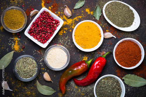 Fototapeta Naklejka Na Ścianę i Meble -  Various spices in a bowls on stone table. Top view.