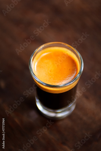 A cup of espresso shot coffee on wooden table background with blank copy space