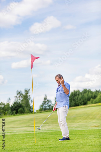 Senior man winning game on a golf course.