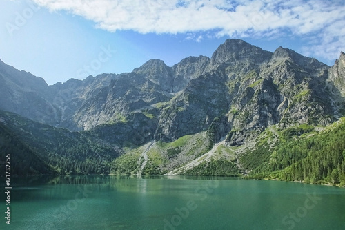 A lovely summer morning in Tatra National park near Morskie Oko - one of the most popular tourist destinations. Crystal clear mountain water reflects the highest peaks of Tatras on the lake. © juste.dcv