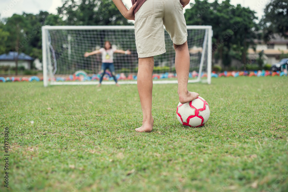 Obraz premium Young boy playing football without shoes
