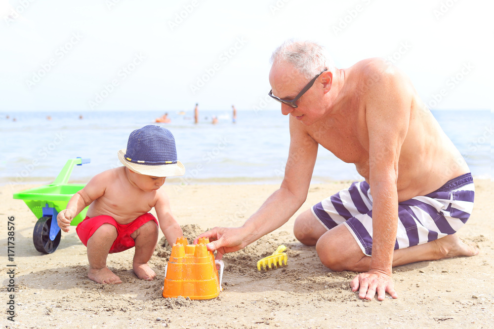Little boy and grandfather playing at the beach Little boy and grandfather playing at the beach
