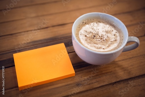 High angle view of adhesive notes by coffee cup
