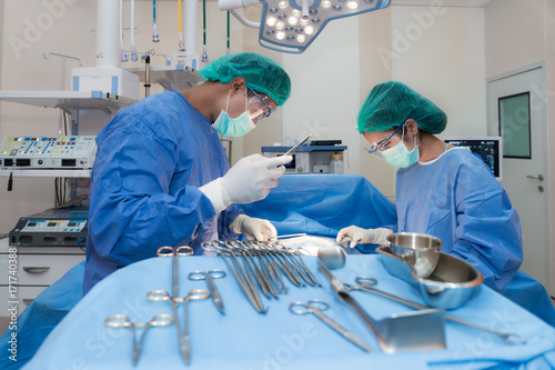 Asian doctor and an assistant in the operating room for surgical venous vascular surgery clinic in hospital.