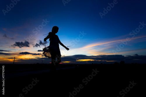 Silhouette of woman posing at sunset or sunrise
