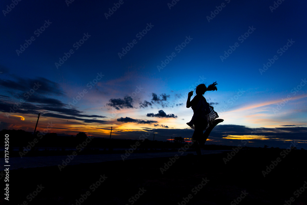 Silhouette of woman posing at sunset or sunrise Silhouette of woman posing at sunset or sunrise