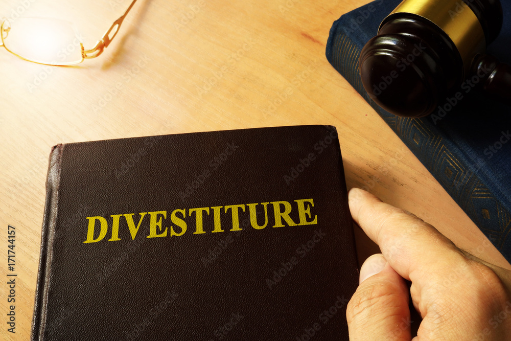 Book with title divestiture and gavel. Book with title divestiture and gavel.