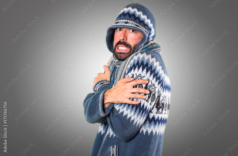 freezing man with winter clothes on grey background
