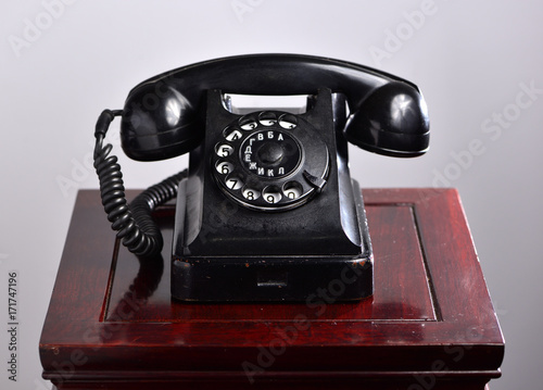 Black retro telephone on a redwood pedestal