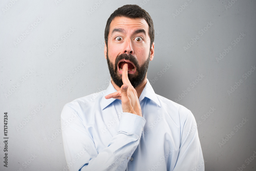 Handsome man with beard making suicide gesture on textured background Handsome man with beard making suicide gesture on textured background