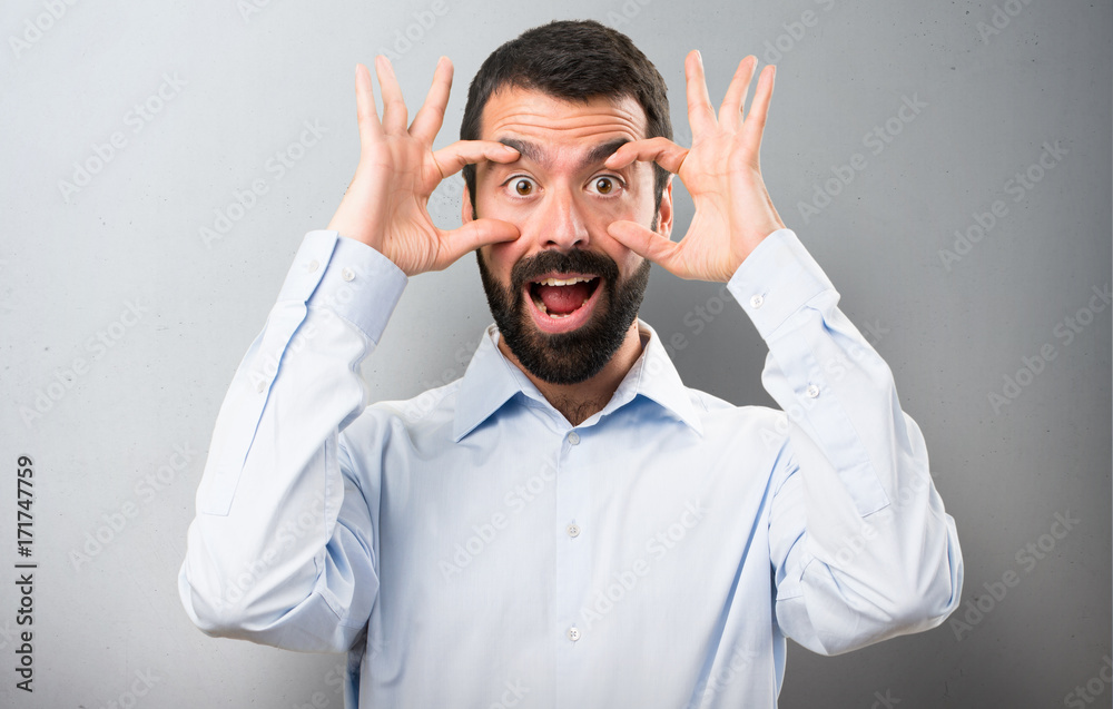 Handsome man with beard showing something on textured background Handsome man with beard showing something on textured background