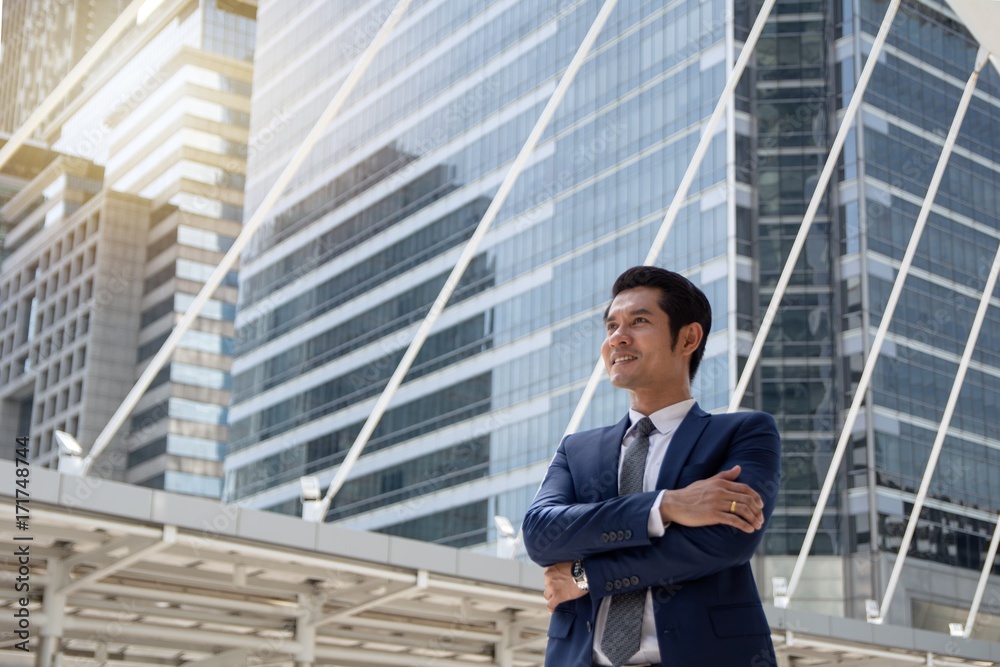 Confident businessman with arm crossed aiming higher target Confident businessman with arm crossed aiming higher target