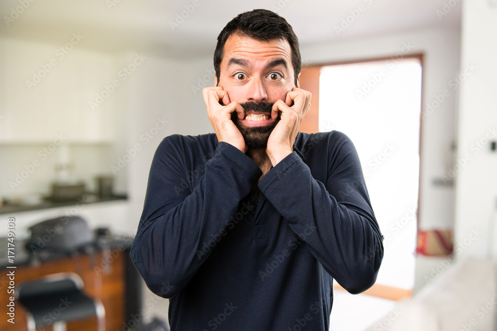 Frightened handsome man with beard inside house Frightened handsome man with beard inside house
