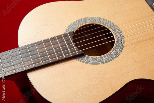 acoustic guitar on red velvet fabric, closeup object