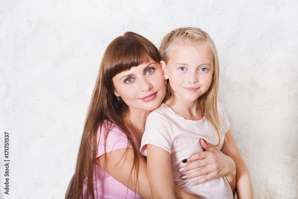 Portrait of beautiful mother and her daughter hugging, looking at camera. Happy family.. Portrait of beautiful mother and her daughter hugging, looking at camera. Happy family..