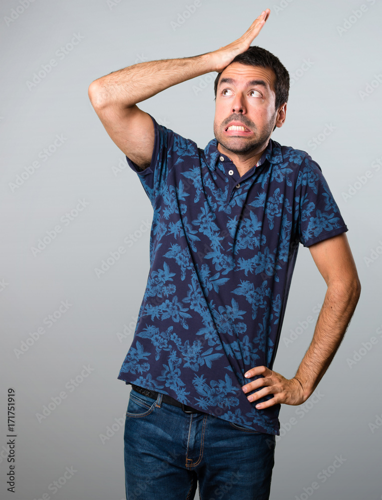 Brunette man having doubts on grey background Brunette man having doubts on grey background