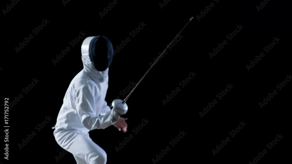 Fully Equipped Skilled Fencer Training with a Foil. He Practices Attack, defense, Leap, Thrust and Lunge. Shot Isolated on Black Background. Shot on RED EPIC-W 8K Helium Cinema Camera. Fully Equipped Skilled Fencer Training with a Foil. He Practices Attack, defense, Leap, Thrust and Lunge. Shot Isolated on Black Background. Shot on RED EPIC-W 8K Helium Cinema Camera.
