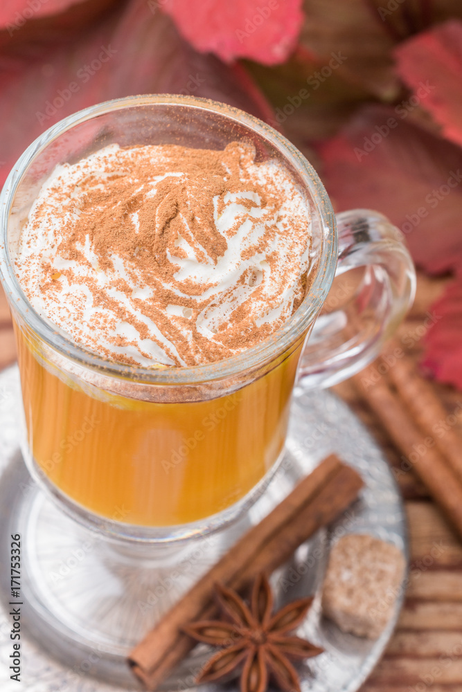 Pumpkin spice latte smoothie with whipped cream and cinnamon in glass Cup on wooden background. Traditional autumn hot or cold beverage. Country style. Selective focus Pumpkin spice latte smoothie with whipped cream and cinnamon in glass Cup on wooden background. Traditional autumn hot or cold beverage. Country style. Selective focus