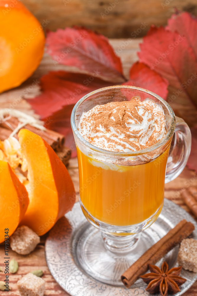 Pumpkin spice latte smoothie with whipped cream and cinnamon in glass Cup on wooden background. Traditional autumn hot or cold beverage. Country style. Selective focus Pumpkin spice latte smoothie with whipped cream and cinnamon in glass Cup on wooden background. Traditional autumn hot or cold beverage. Country style. Selective focus