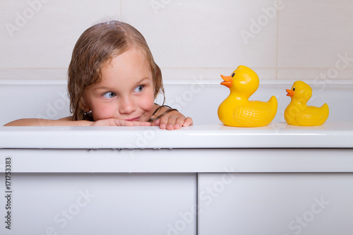 baby girl taking bath with foam and toys