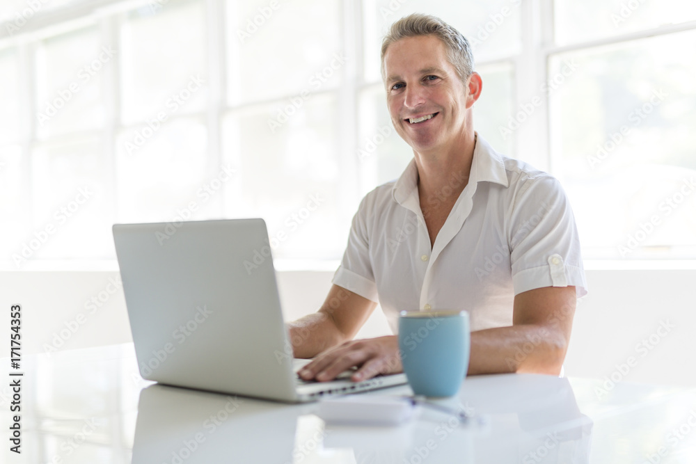 Mature Man Using Laptop On Desk At Home Mature Man Using Laptop On Desk At Home