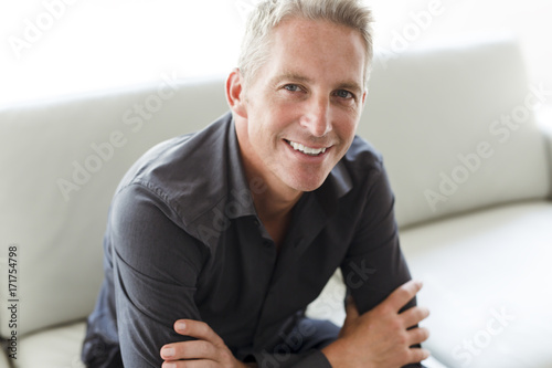 Portrait of single 40s man sitting in sofa