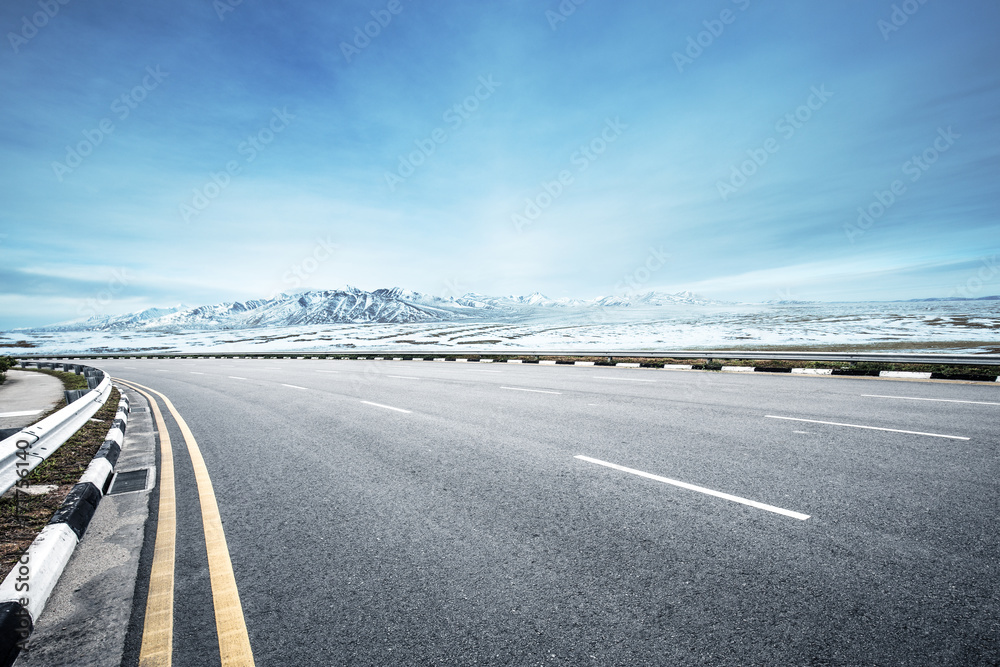 empty asphalt road with snow mountains in blue sky empty asphalt road with snow mountains in blue sky