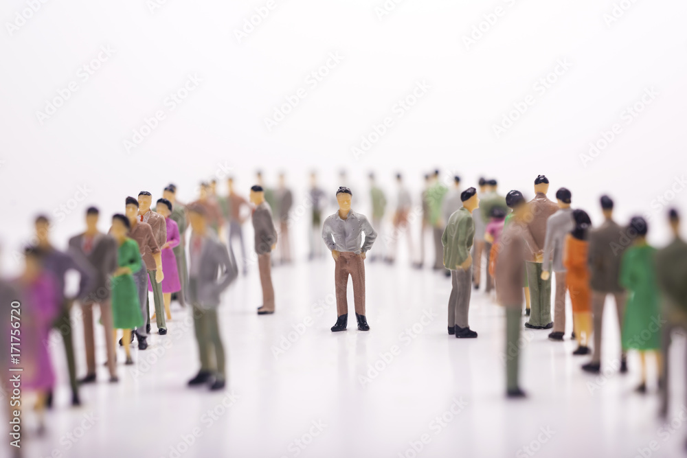 Miniature people in line across to each other with bosses in the middle over white background. Miniature people in line across to each other with bosses in the middle over white background.