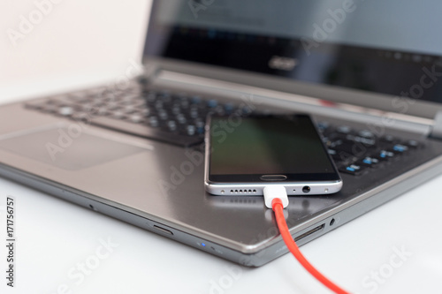 Wallpaper Mural Close-up of charging a smartphone from a laptop. Torontodigital.ca