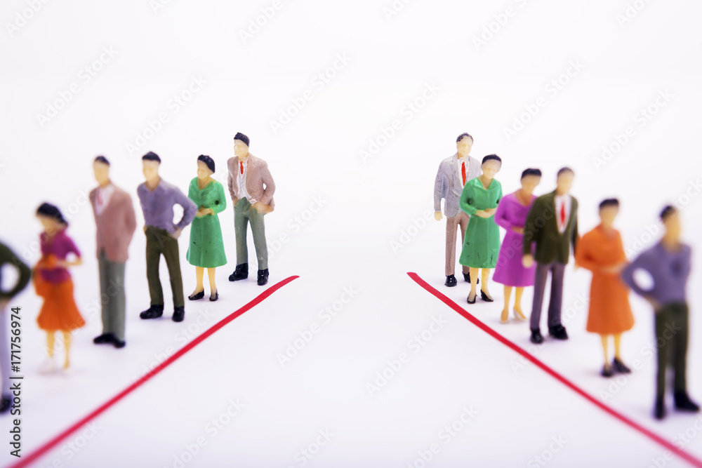 Miniature people in two lines across to each other over white background. Miniature people in two lines across to each other over white background.
