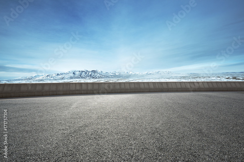 empty asphalt road with snow mountains in blue sky
