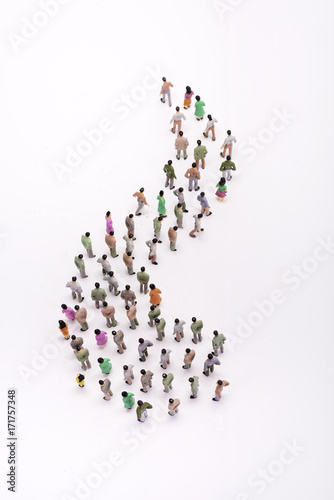 Line of miniature people view from above, over white background.