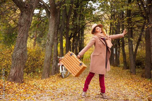 travel concept funny young woman walk with suitcase in bright autumn city park background copy space 