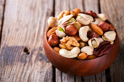 Nuts Mixed in a wooden plate.Assortment, Walnuts,Pecan,Almonds,Hazelnuts,Cashews,Pistachios.Concept of Healthy Eating.Vegetarian.selective focus.