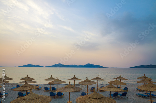 Row sunbeds and umbrellas on beach in morning. © cegli
