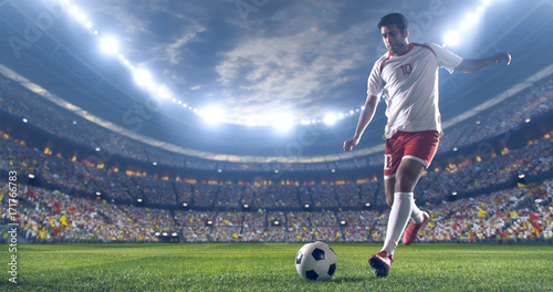 Soccer player kicks the ball on the soccer stadium. He wear unbranded sports clothes. Stadium and crowd made in 3D. photo