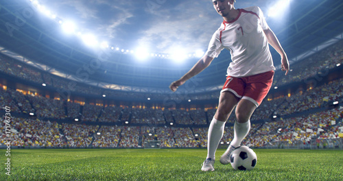 Piłkarz kopie piłkę na stadionie piłkarskim. Nosi niemarkową odzież sportową. Stadion i tłum wykonany w 3D.
