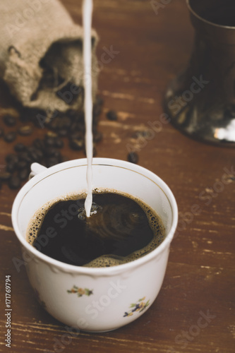 Pouring Milk into Coffee, coffee ground around