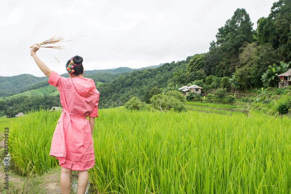 Asian woman relaxing in rice terraces fields on holiday Asian woman relaxing in rice terraces fields on holiday