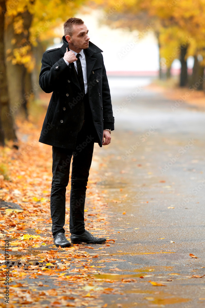 Attractive man in black coat in autumn forest. Fashion and clothing concept. Man's style. Attractive man in black coat in autumn forest. Fashion and clothing concept. Man's style.