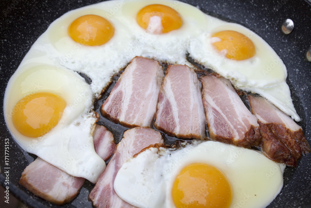 Fried eggs and bacon in pan Fried eggs and bacon in pan