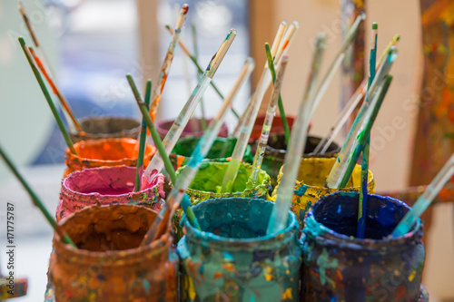 An Artists's Mason Jars of Paint with Brushes