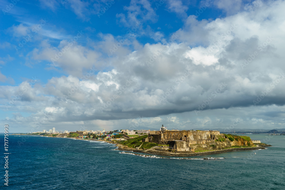 Scenic view of historic colorful Puerto Rico city in distance with fort in foreground