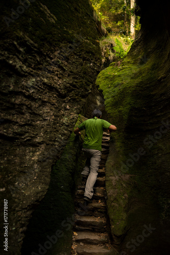 Young adult active man exploring scenic gorge in Uriezzo Italy in sunny summer day outdoor. photo