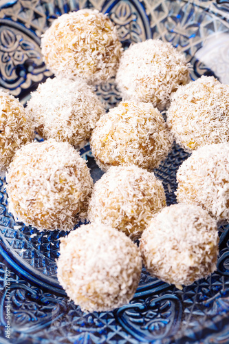 Candy with dates, dried apricots and nuts, vertical, selective focus, top view, hands in frame, ingredients