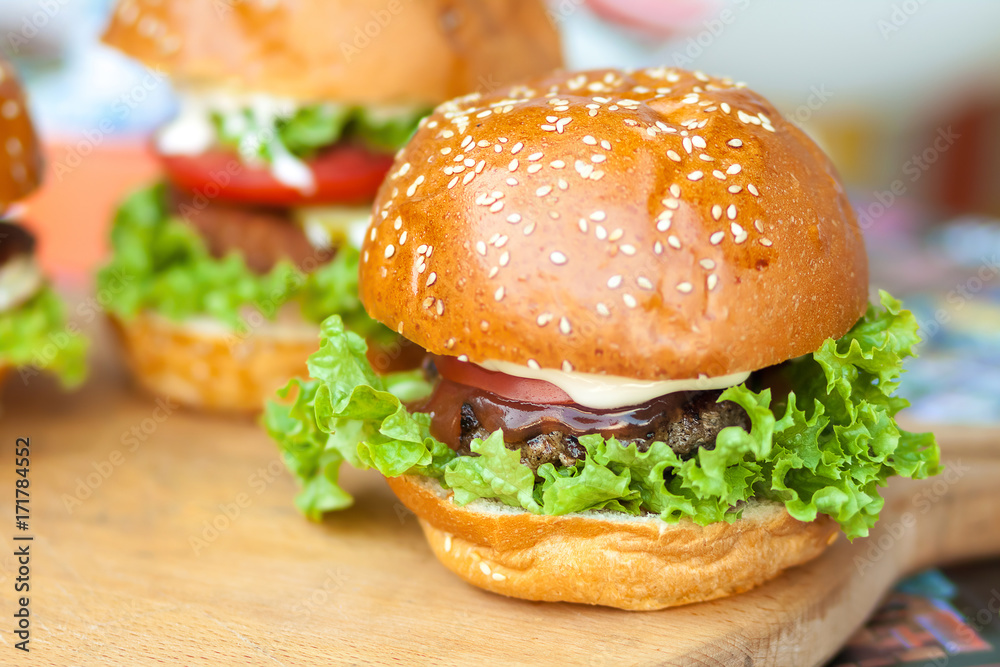 Delicious and juicy burger with salad lettuce and pickled cucumber Delicious and juicy burger with salad lettuce and pickled cucumber